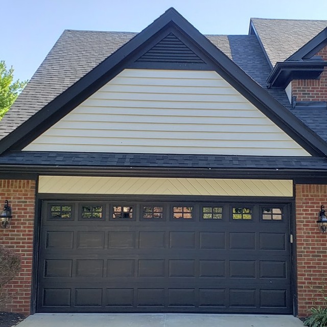 Black garage door on a brick home