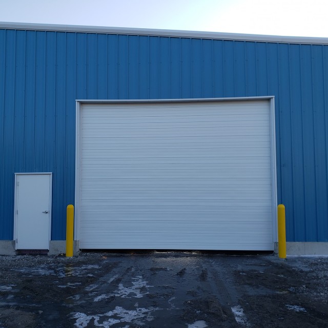 New large white garage door on warehouse