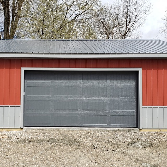 Black garage door on a red and gray building